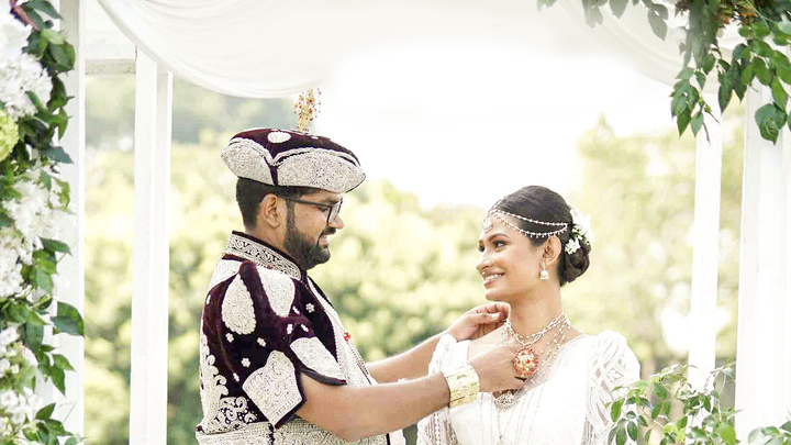 A groom tying gold chain around bride's neck on their wedding day, shows love and affection in a happy moment. mangala yojana 2024, matrimony sri lanka, sl marriage proposals, mangala yojana, marriage proposal in sri lanka, sri lankan matrimony, sri lanka marriage proposal sites.