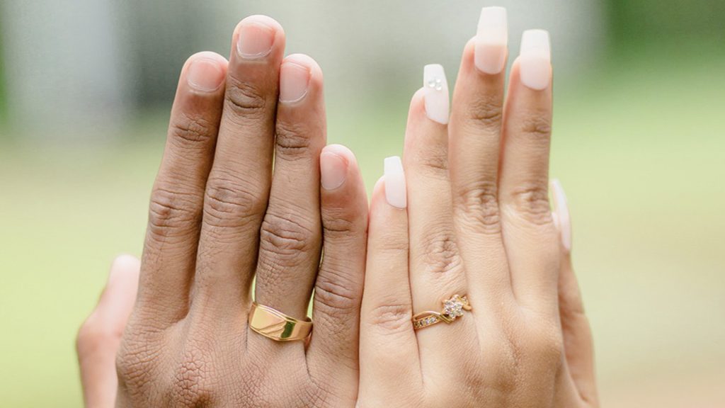 image of bride and groom's hands with wedding rings, shows marriage and love, captured beautifully in this wedding moment.