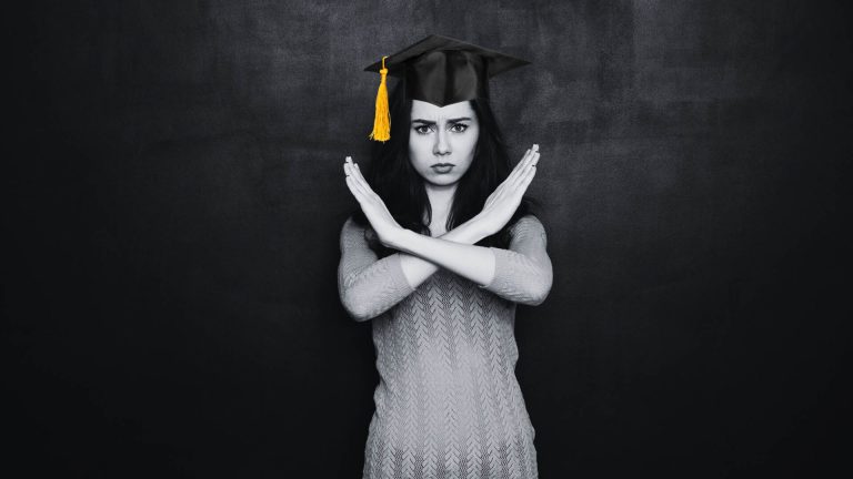 A woman wearing a graduation cap makes a celebratory gesture, symbolizing her success and accomplishment in education.