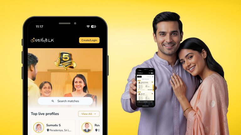 A smiling couple in traditional attire holds a smartphone showing a dating and wedding proposal website app celebrating its 5th anniversary, representing mangala yojana, matrimony Sri Lanka, SriLanka matrimony, and marriage proposals in Sri Lanka, including Poruwa.lk | ශ්‍රී ලාංකීය මංගල යෝජනා, poruwa ceremony services, LankaMatrimony, hitad marriage proposals, Catholic marriage proposals, Buddhist matrimony, Liyathabara marriage proposals in Sri Lanka, Lanka brides and grooms, and Purahanda LK platforms for finding the ideal marriage proposal Sri Lanka.